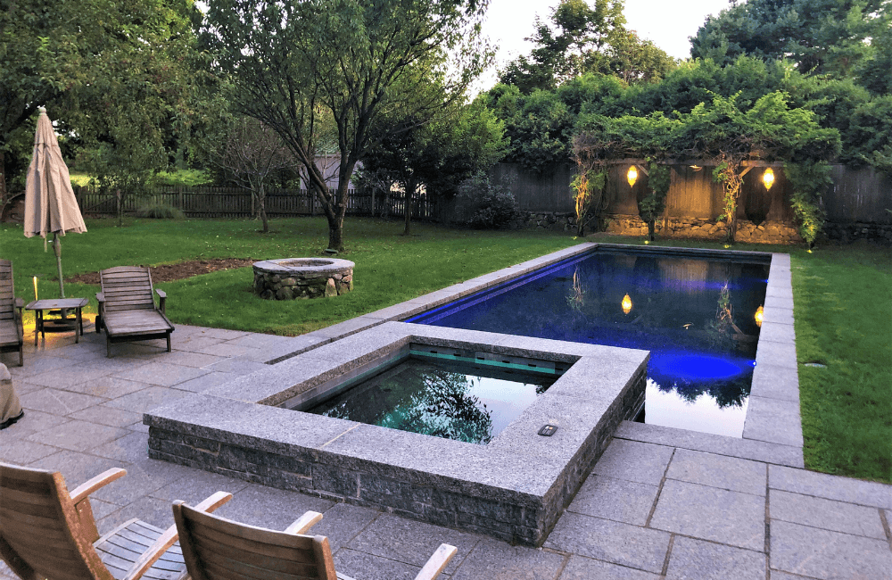 Large backyard with a swimming pool with attached spa